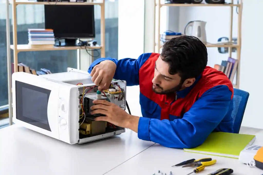 Technician repairing internal microwave components.
