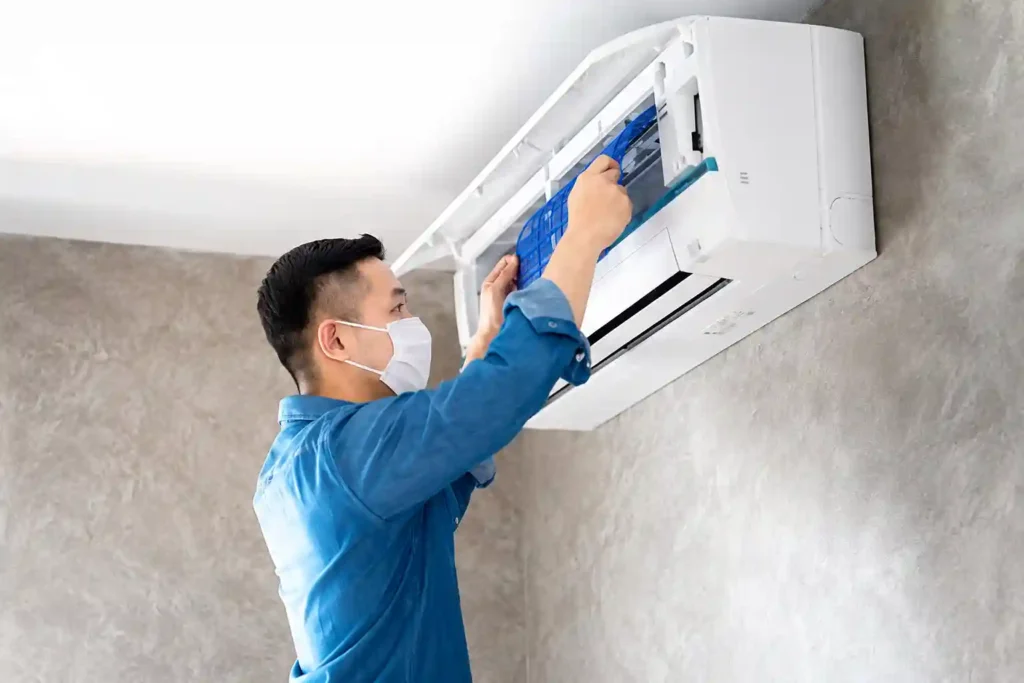 HVAC technician performing detailed maintenance on a wall-mounted split AC.